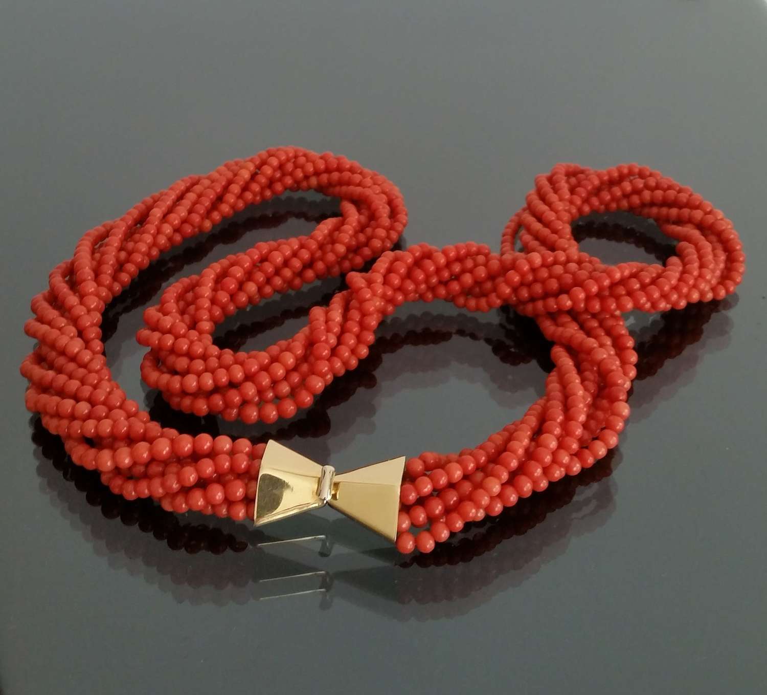A long coral multi strand necklace